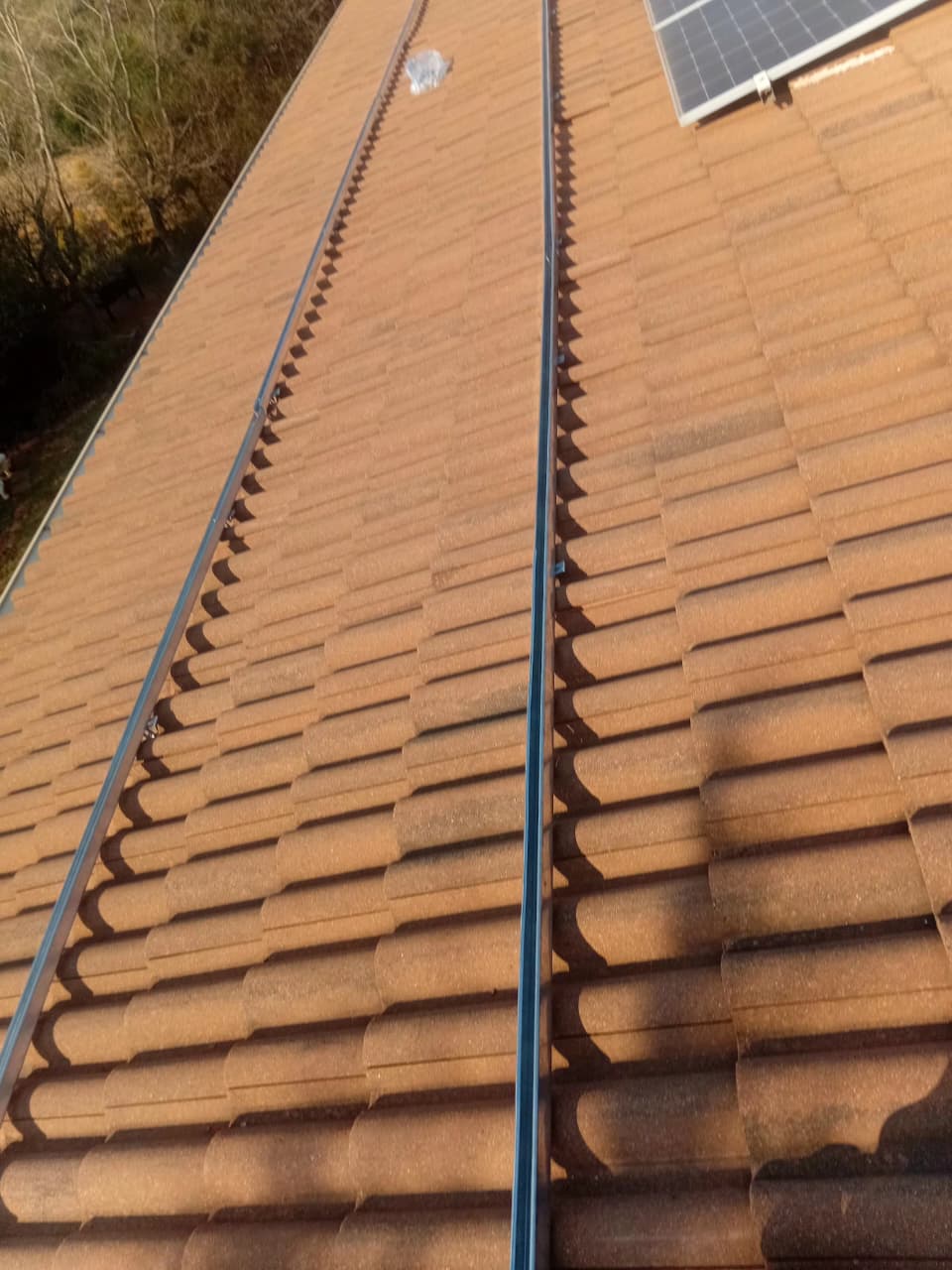 Mounting rails fixed to a tiled roof before panel installation